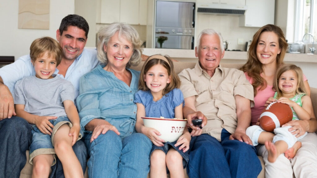 Three generations of a family sitting together at home