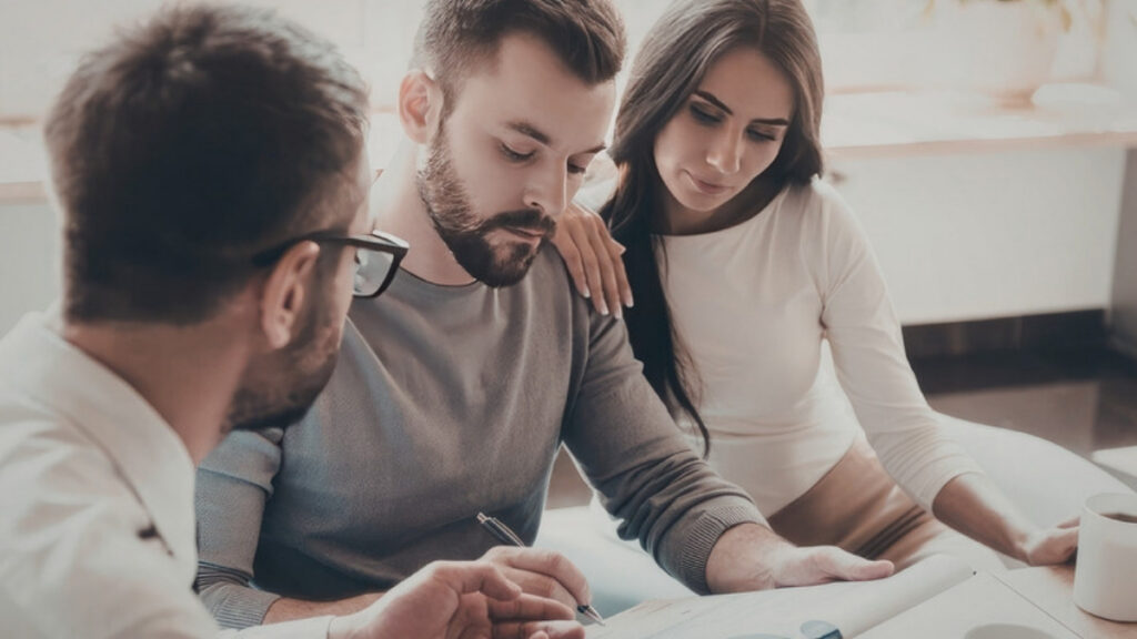 A couple going through documents with their adviser