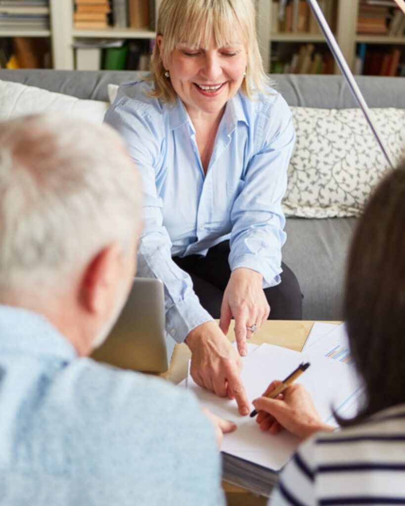 An estate planning lawyer in Camarillo pointing out where an older couple signs their planning documents
