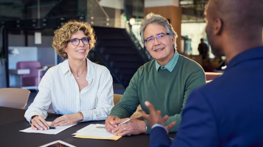An older couple going over their plan with an estate planning lawyer in Camarillo at a conference table