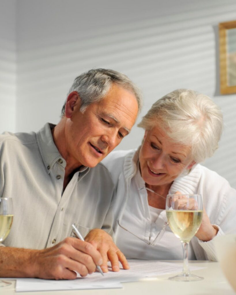 An older couple writing down questions at the kitchen table before meeting an estate planning lawyer in Camarillo