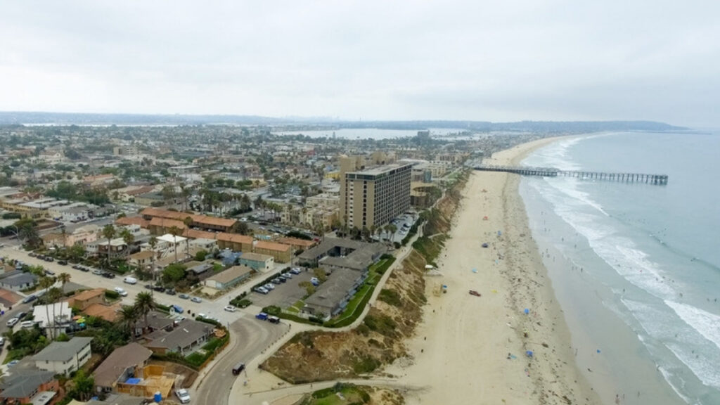 An aerial view of a flat Southern California coastal city and its beach