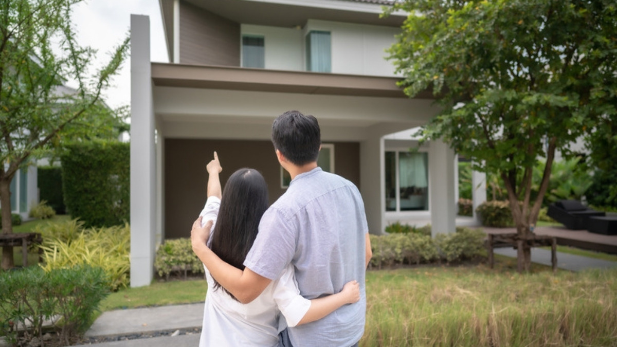 A young couple outside their first home, first time clients of an estate planning lawyer in Sherman Oaks