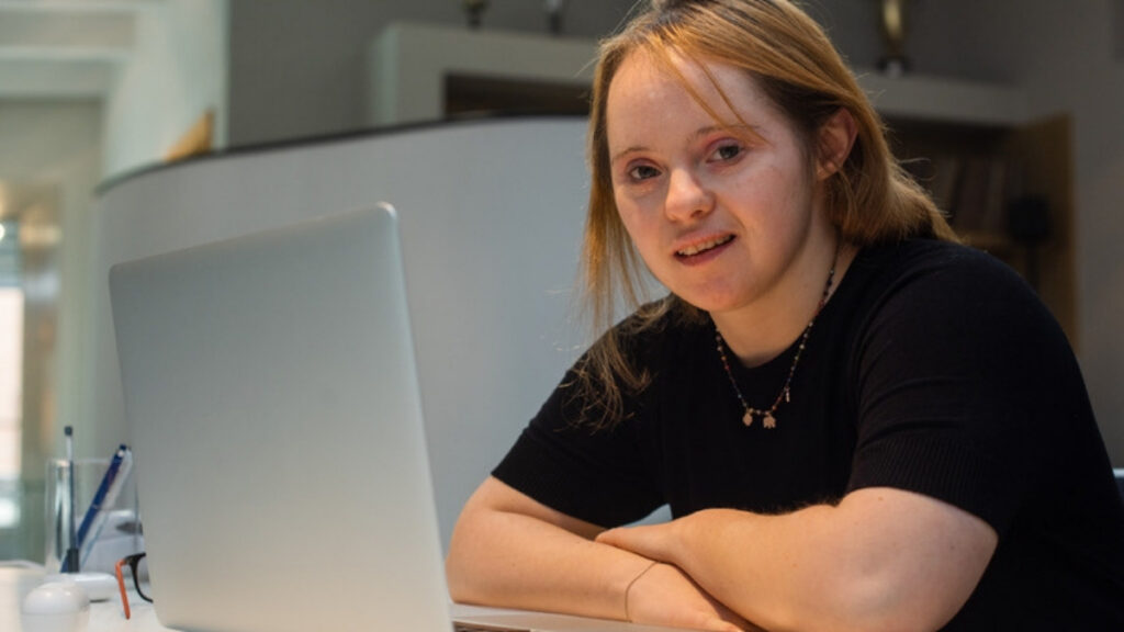 A young woman with a disability at her laptop, at the age a Camarillo special needs trust attorney plans around