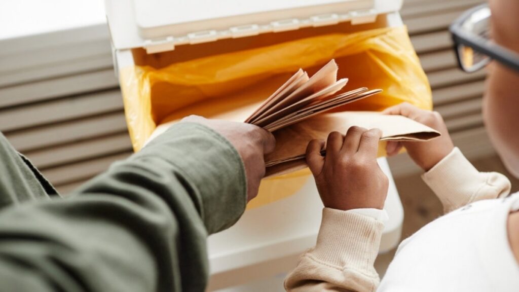 Family members pulling old envelopes out of a storage box