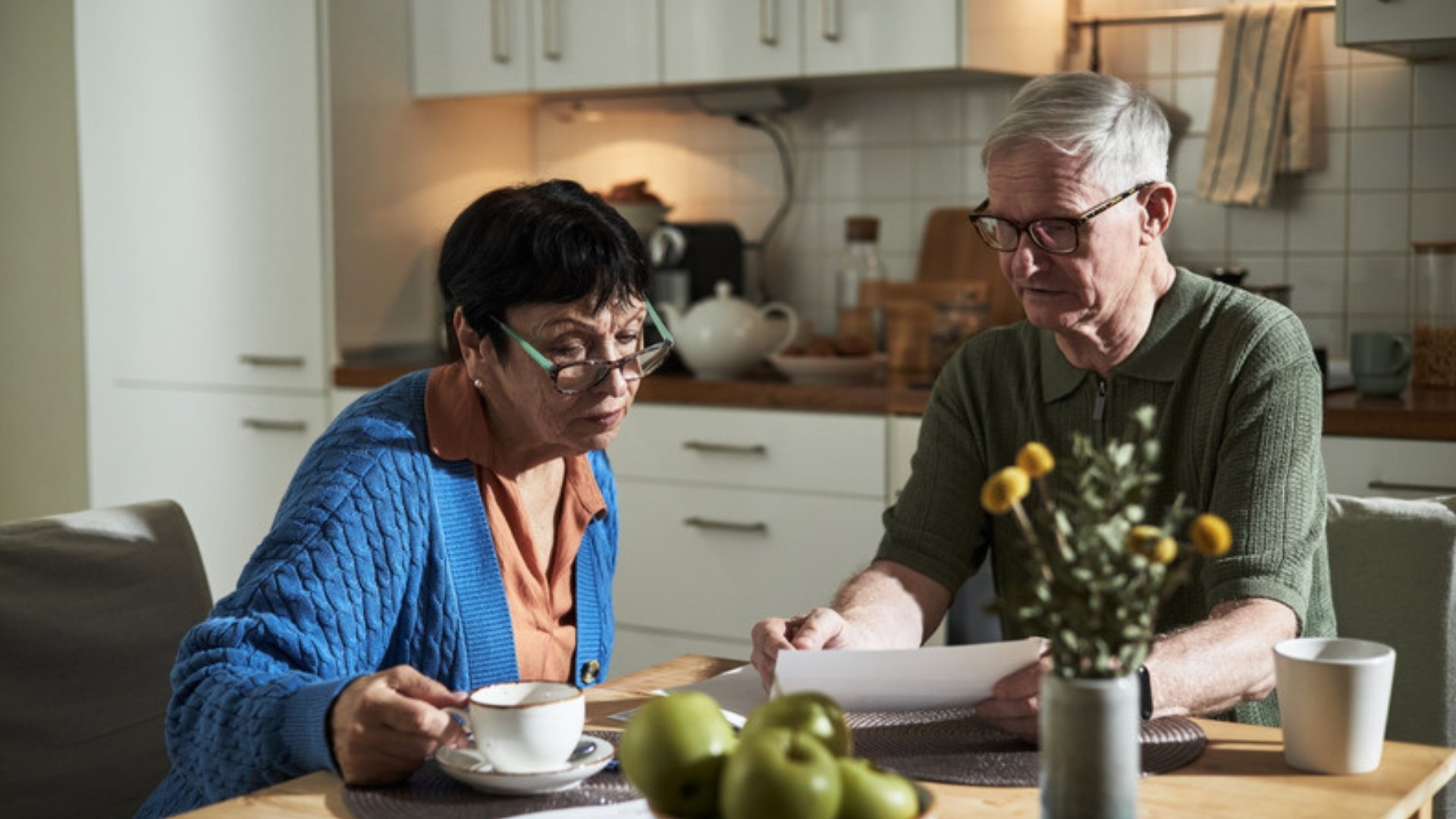 Older couple reading papers at a kitchen table to learn what is a pour over will